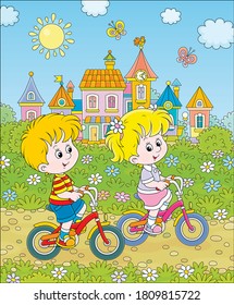 Little children riding bicycles near a cute small town with colorful houses among green trees on a sunny summer day, vector cartoon illustration