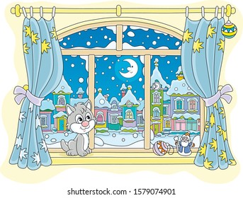 Little curious kitten sitting on a windowsill, looking through a window at the bright moon over a beautiful snow-covered town on a frosty winter night, vector cartoon illustration