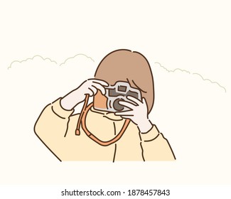 Little cute girl taking a picture with vintage camera. Hand drawn style vector design illustrations.