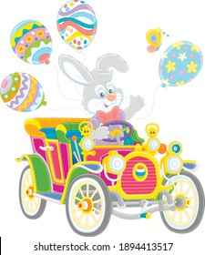 Little Easter Bunny friendly smiling, waving in greeting and driving a colorful toy retro car decorated with bright holiday balloons, vector cartoon illustration isolated on white