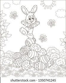 Little Easter Bunny on a pile of colorfully decorated eggs on grass on a sunny spring day, black and white vector illustration in a cartoon style for a coloring book