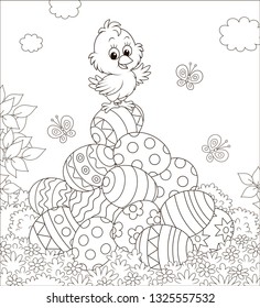 Little Easter Chick on a pile of colorfully decorated eggs on a sunny spring day, black and white vector illustration in a cartoon style for a coloring book