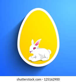 Little Easter Rabbit in the yellow Easter Egg on blue background. EPS 10.