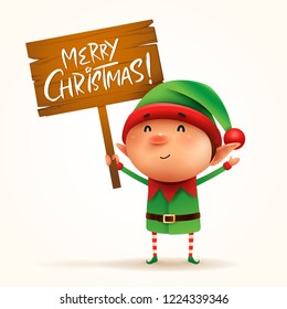 Little elf holds a wooden board with Christmas greetings. Isolated. 