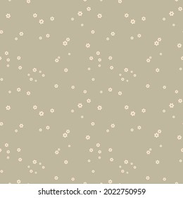 Little flowers chaos seamless pattern. Polka dot background in mustard and beige shades. Small blossom snowflakes