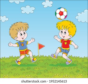 Little football players with a colorful ball at a match or training on a green sports field on a bright summer day, vector cartoon illustration
