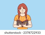 Little girl with bible in hands studies prayers and gospel before going to christian church. Happy child believer in catholic religion holds bible illuminating face and smiles feeling support of lord