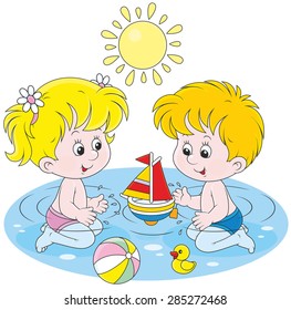 Little girl and boy playing with their toys in water in a summer day