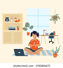 Little girl doing yoga at home using a laptop. Concept for learning at home, yoga school online. Place for text