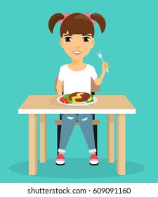Little girl eats sitting at the table. The girl with a smile on her face. Holding a fork. Health. Happy child.