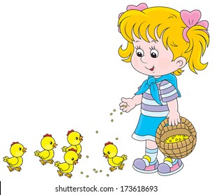 Little girl feeding small yellow chickens