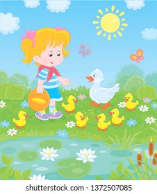 Little girl feeding a white duck and small yellow ducklings among flowers by a pond with water-lilies on a sunny summer day, vector illustration in a cartoon style