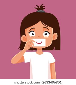 
Little Girl Holding a Smiling Card Vector Cartoon Illustration. Child feeling depressed trying to hide her true feelings of anxiety 
