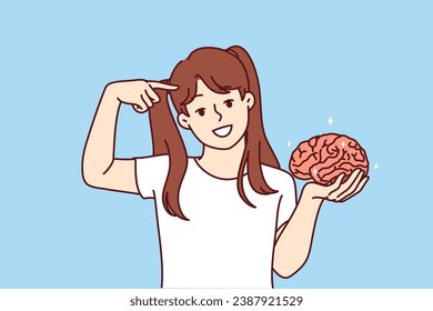 Little girl holds brain in hand and points finger at head, calling to develop intelligence and take care of increasing iq. Smart child with high iq for advertising childrens educational courses