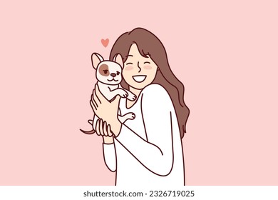 Little girl hugs puppy given for birthday and rejoices at dog become best friend for child. Happy female teenager with miniature dog enjoys interacting with cute pet adopted from shelter