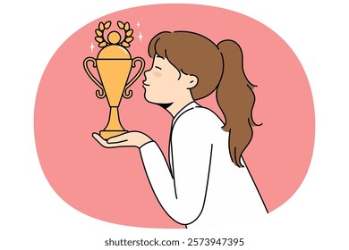 Little girl leader kisses golden cup won in school olympiad or sports competition. Schoolgirl leader with trophy received for achievements in education or outstanding athletic skills