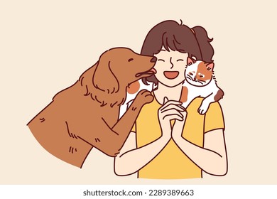 Little girl with pets enjoys communicating with cat sitting on shoulder and dog licking face. Teenage girl laughs rejoicing at presence of pets and makes friends with kitten and puppy 