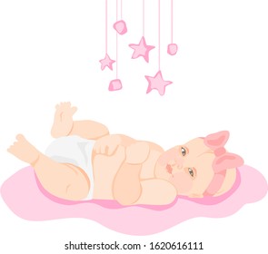 little girl with a pink bow on her head lies on a pink background over which pink toys hang.comfortable stay of the baby in the house after birth.stages of development of a newborn baby.