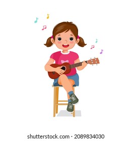 little girl playing a guitar or ukulele and singing sitting on a wooden chair