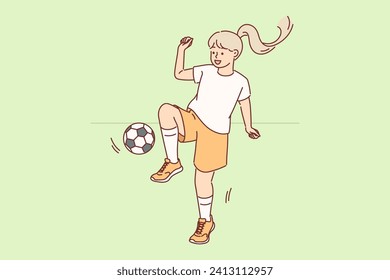 Little girl plays football with ball during outdoor training session, preparing for school tournament. Child dreams of becoming professional football player and playing in international championships.