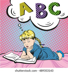 Little girl reading book on a bed. Vector illustration in comic pop art style. Girl studying alphabet.
