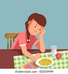 A little girl refusing food, kid does not want to eat. The girl sits at the table and does not want to eating