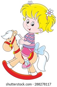 little girl riding a toy horse