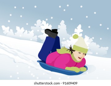 Little girl sledding in the snow slope