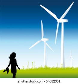 A little girl standing in front of some windmills.