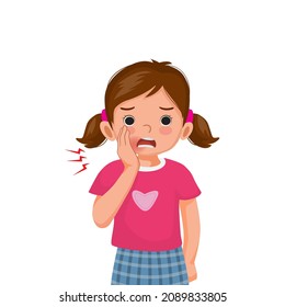 Little girl toothache touching her cheek feeling painful. Kid with dental problem and sensitive teeth showing upset facial expression