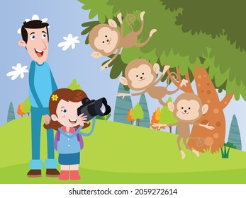 Little girl using a camera to taking photo of monkey at the zoo while enjoying leisure time with her father