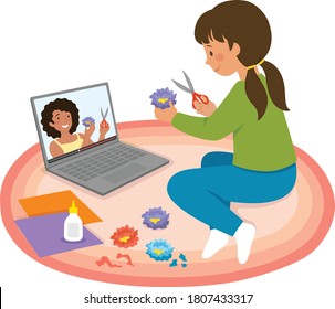 Little girl watching craft tutorial video on a laptop and making paper flowers