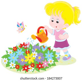 Little girl watering flowers on a flowerbed