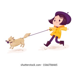 Little girl wearing, dressed a jacket walking the dog on leash.