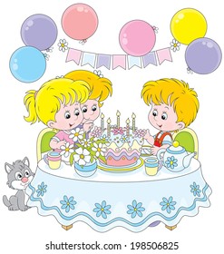 Little girls and boy having fun at the holiday table with a birthday cake