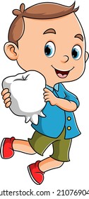 The little healthy boy is holding the tooth model of illustration