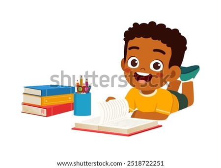 little kid reading a book while lying on stomach on the floor