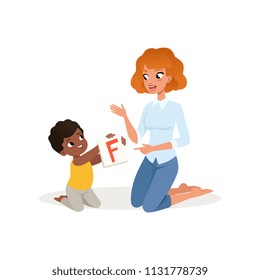 Little kid showing flash card with letter F to his teacher. Child development and education center. Flat vector design