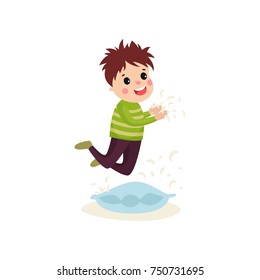 Little naughty kid boy jumping on the pillow, feathers flying around him