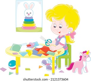 Little preschool girl cutting outlines and figures from color paper with scissors and making a funny picture of a cute toy bunny, vector cartoon illustration isolated on a white background