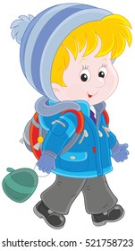 Little schoolchild in a winter jacket, a warm hat and mittens going with his schoolbag