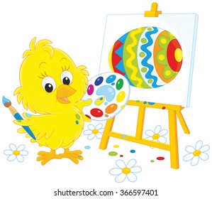 Little yellow chick drawing a colorfully decorated Easter egg