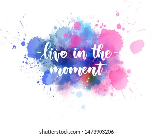 Live in the moment - inspirational handwritten modern calligraphy lettering text on multicolored watercolor paint splash background.