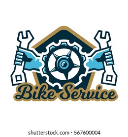 Logo Bike Service. A Bicycle Sprocket And Hand Holding A Wrench On The Sides. Repair, Tune Mountain Bike. Vector Illustration. Flat Style 