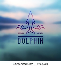 logo of dolphin and waves on blurred background of seascape, vector template for travel agency