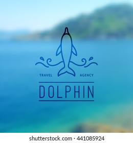 logo of dolphin and waves on blurred background of seascape, vector template for travel agency