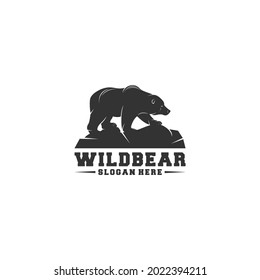 logo illustration of a bear walking on a rock on a white background