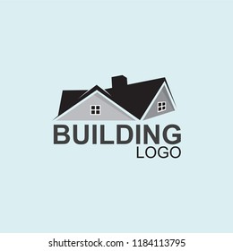 A logo on a light blue background shows a stylized house with a dark roof and gray walls with windows. Below, "BUILDING" is in bold gray, and "LOGO" is in smaller gray font.