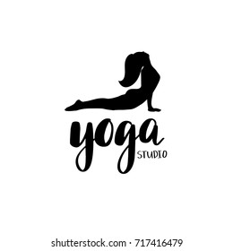 Logo for yoga studio or meditation class. Spa logotype design.Silhouette of lying woman and lettering phrase Yoga studio. Vector illustration for t-shirt print, yoga mat, towel, poster, business card.