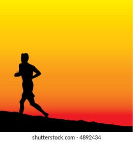 A lone male runner on the beach at sunset